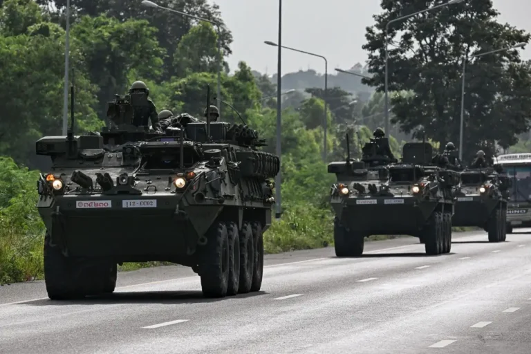 Thai Army soldiers ride armored vehicles