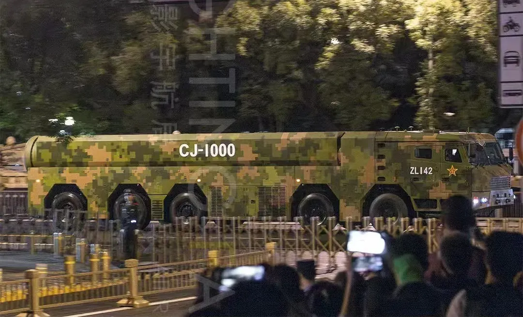 Side-view launcher truck labeled CJ-1000 at military parade.