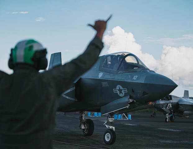 Marine Corps plane captain from VMFA-225 signals an F-35B taxiing after landing during USSOUTHCOM ops, Sept. 13, 2025